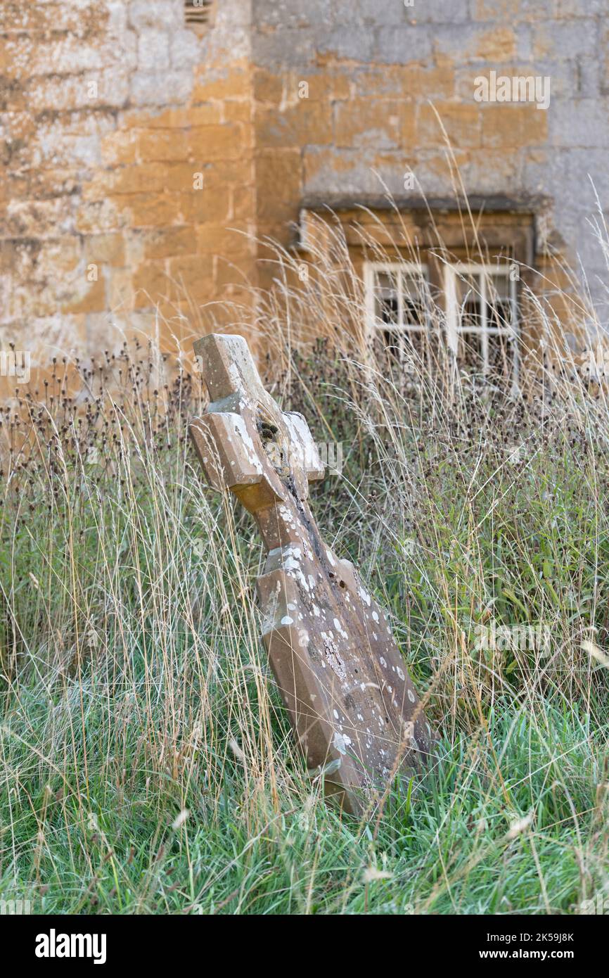 Old grave stone in the long grass at St Peter & St Paul Churchyard, Blockley, Gloucestershire, Cotswolds, England Stock Photo