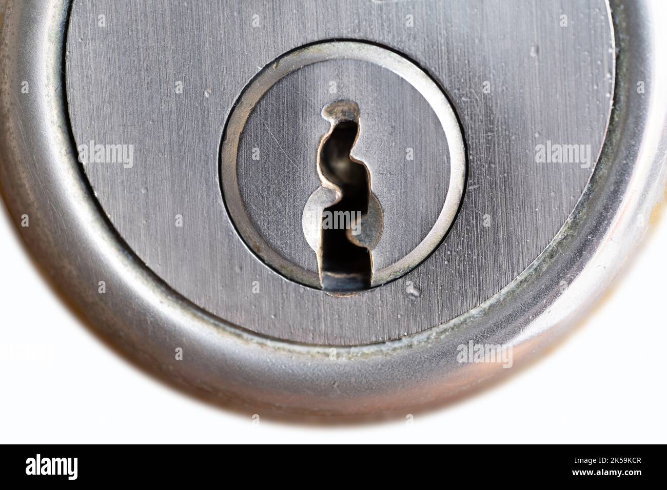 Metal key plate with keyhole of a cylinder lock in a door. Isolated on