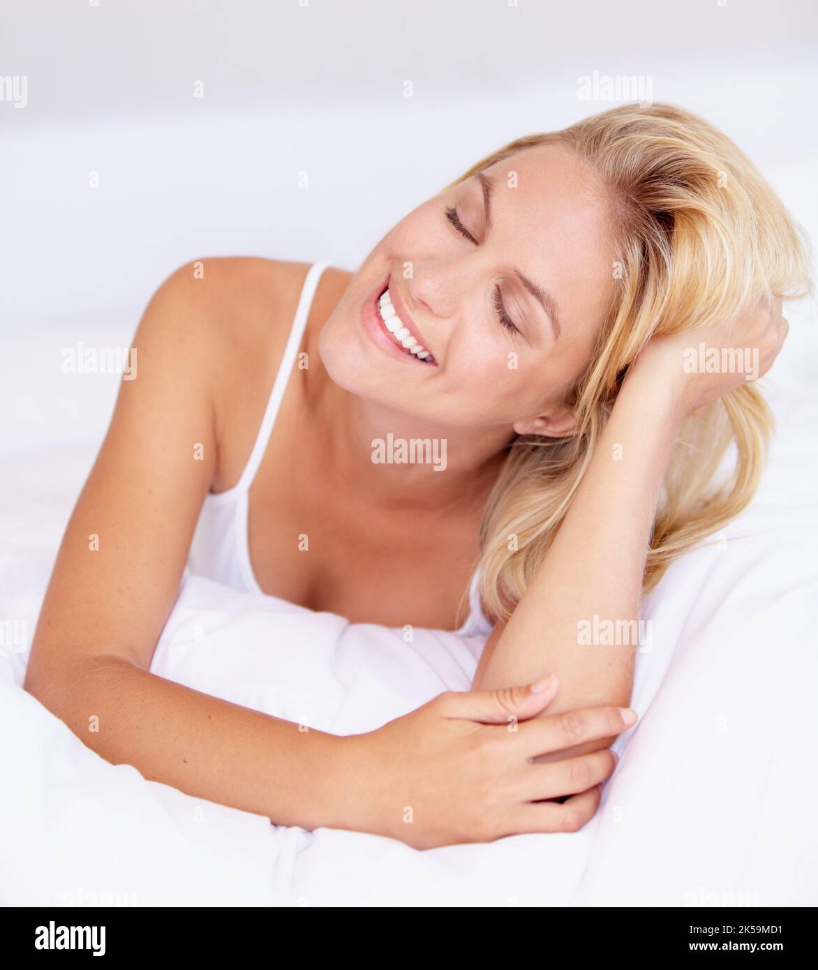 Relieved that she can finally relax. A beautiful young woman lying on her bed. Stock Photo