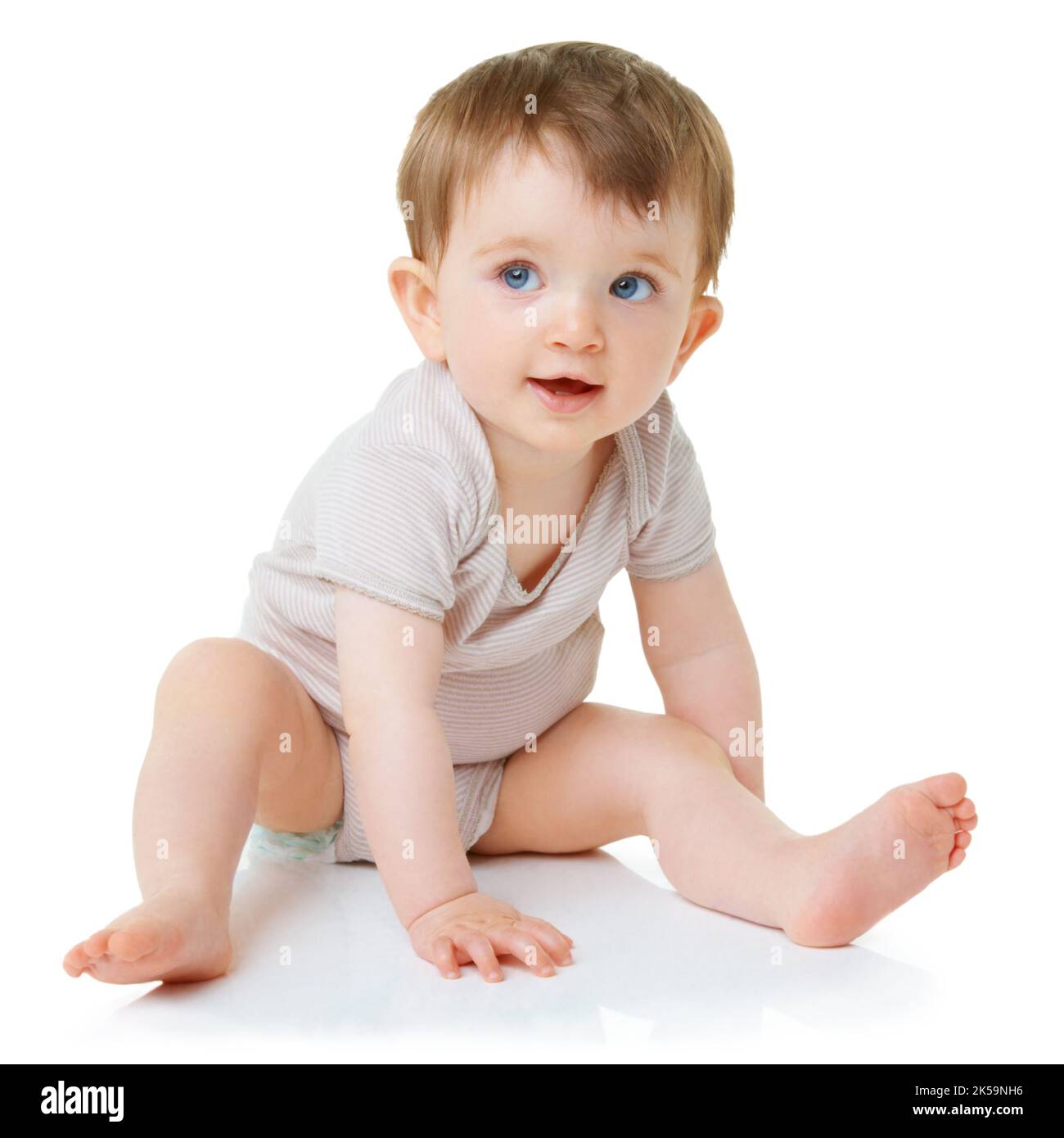 She wants to walk. An adorable baby girl sitting down isolated on white