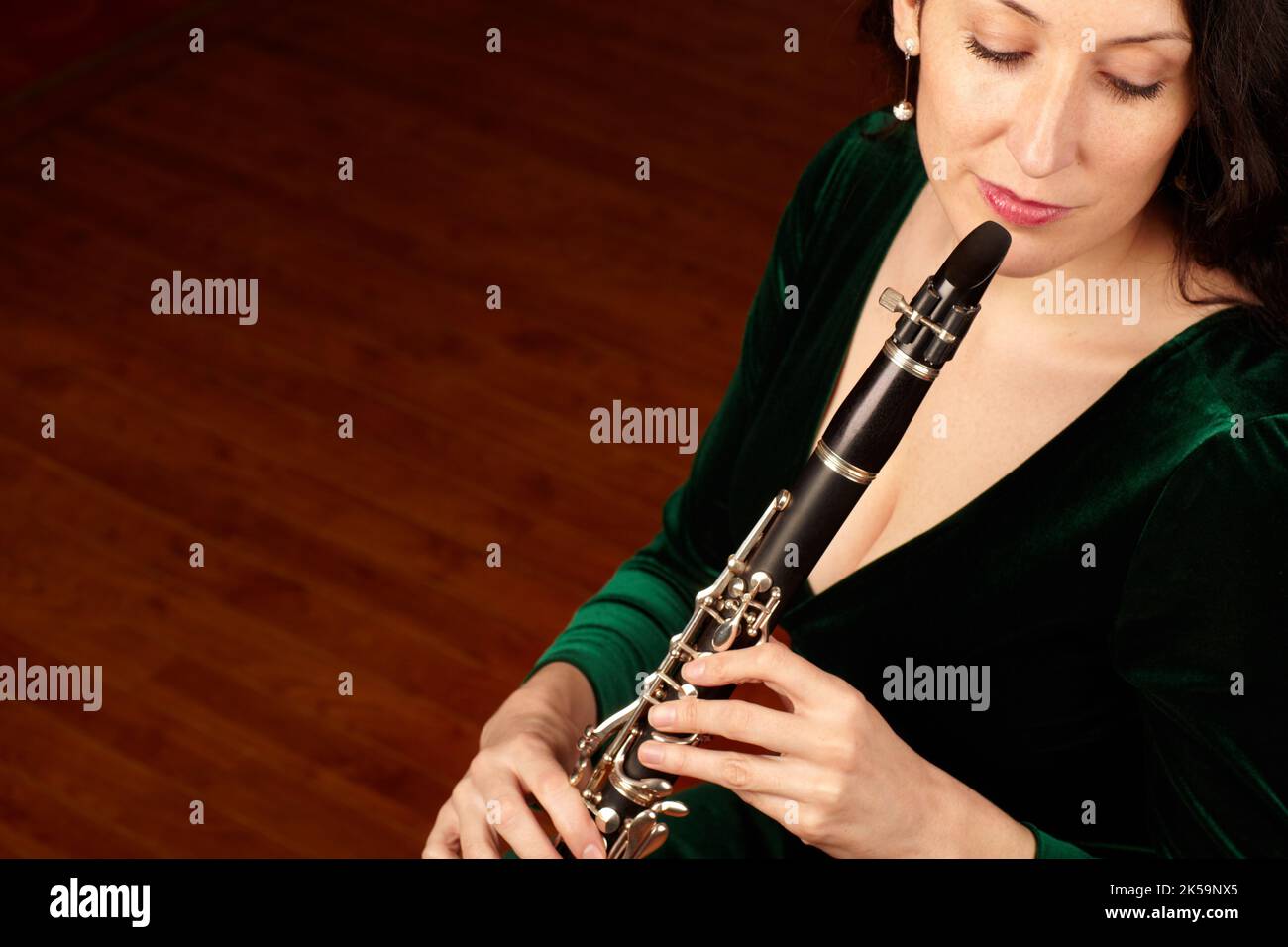 Classical culture. A beautiful clarinetist sitting and playing her instrument - copyspace. Stock Photo