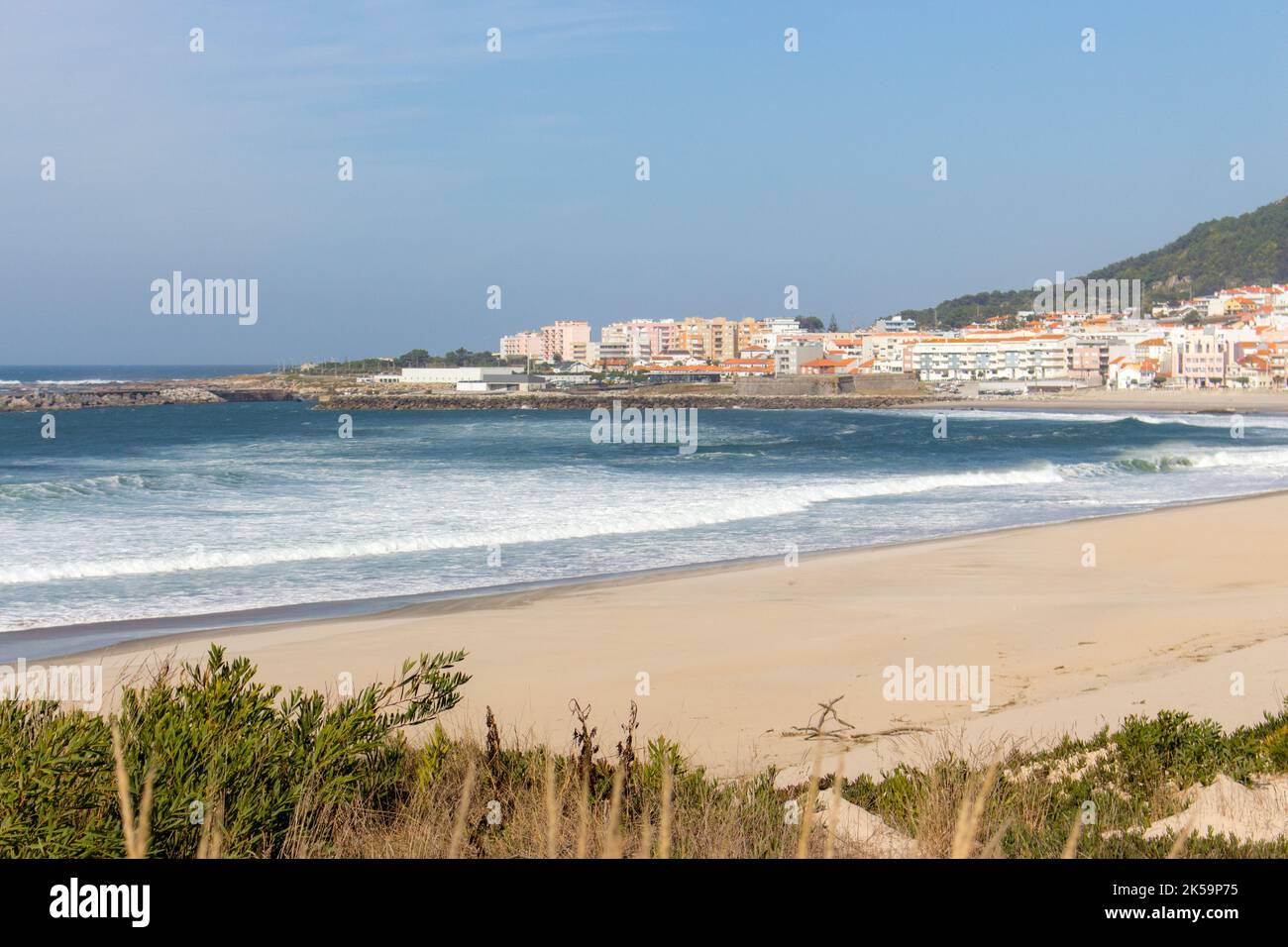 Wide empty beach with beautiful waves and white town on background. Vila Praia de Ancora, Portugal, landmark. Coastal town. Stock Photo