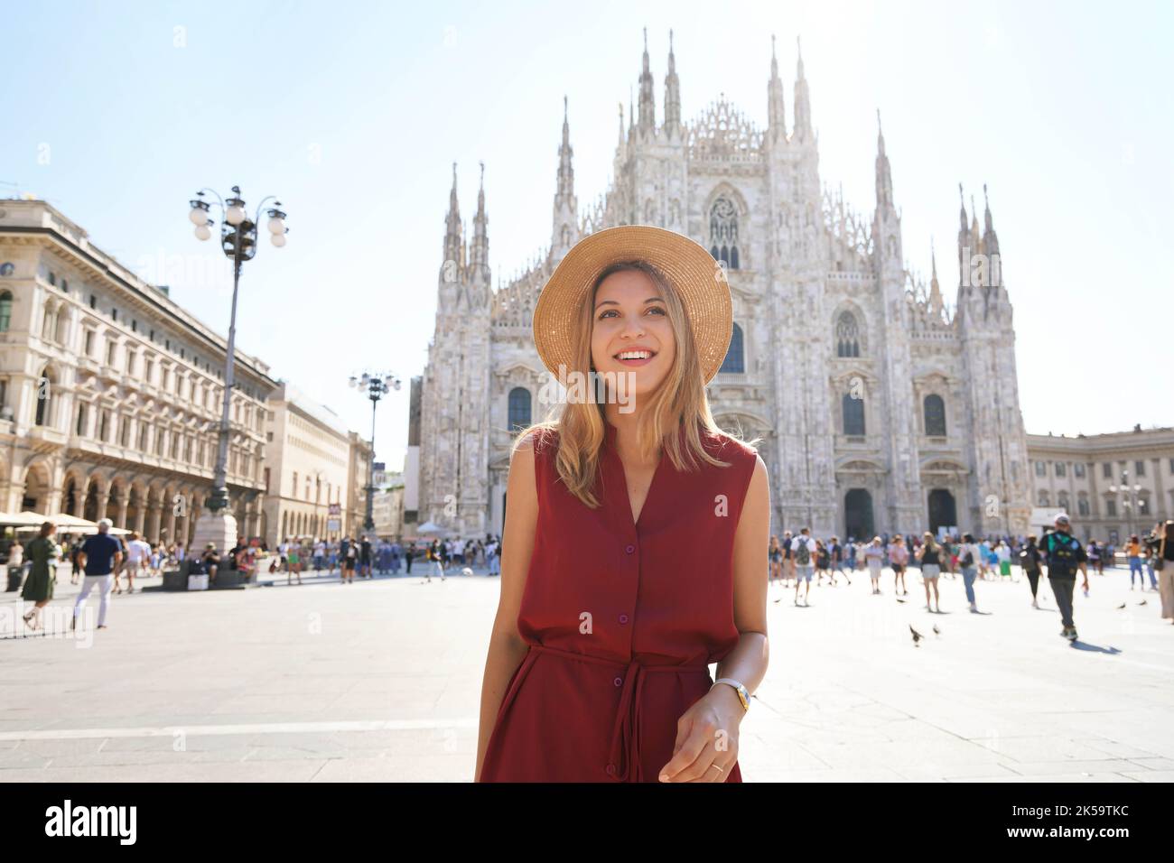 Milan fashion. Young chic woman walking in main square smiling on sunny day. Stock Photo