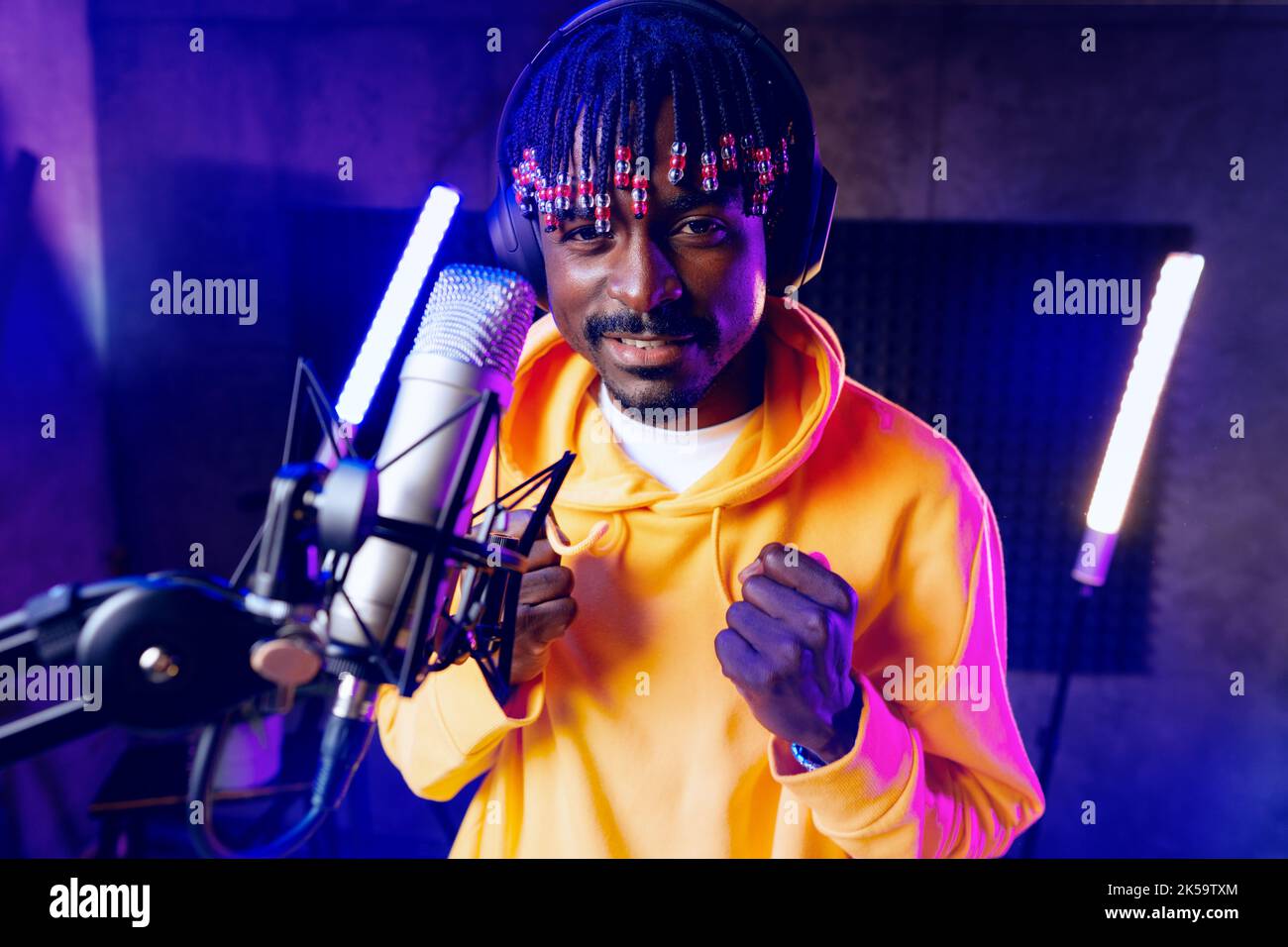 Young African performer recording his new track in recording studio ...