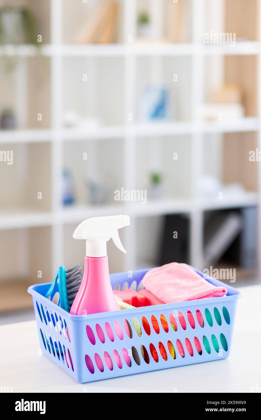 Cleaner tools. Home hygiene. Professional service. Domestic chores. Basket with detergent spray soapy sponges brush microfiber cloth for cleaning room Stock Photo