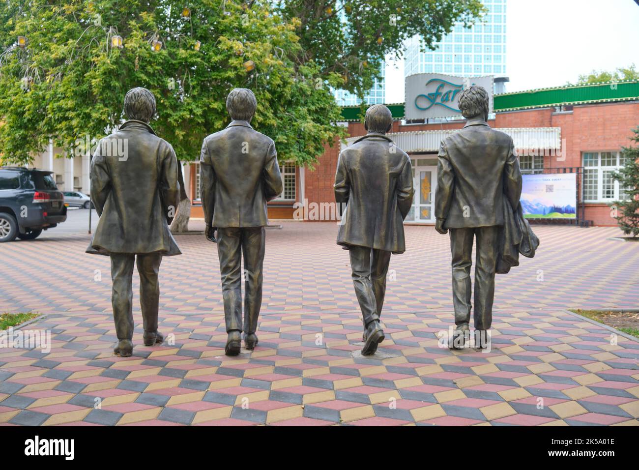 A bronze statue of the iconic pop, rock band, The Beatles, walking. View of their backs. In Astana, NurSultan, Kazakhstan. Stock Photo