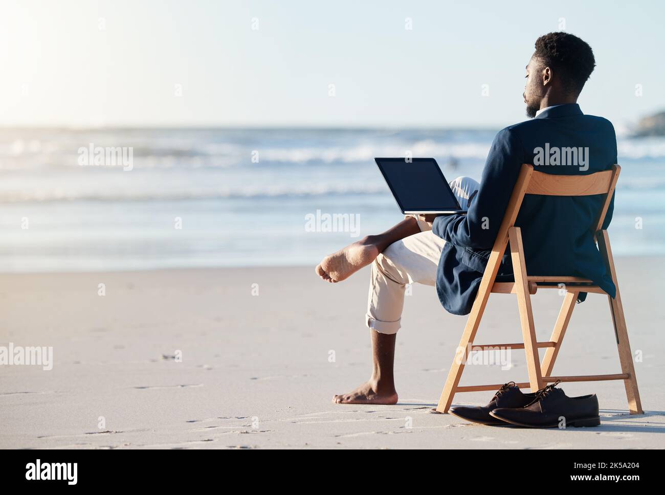 Beach vacation, work travel and black man doing business on holiday reading an email with 5g internet while working by ocean. Relax, break and happy Stock Photo