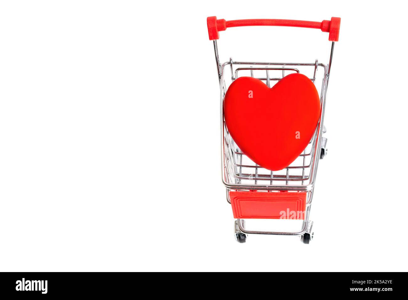 Large red heart shape placed in a small push cart isolated on white