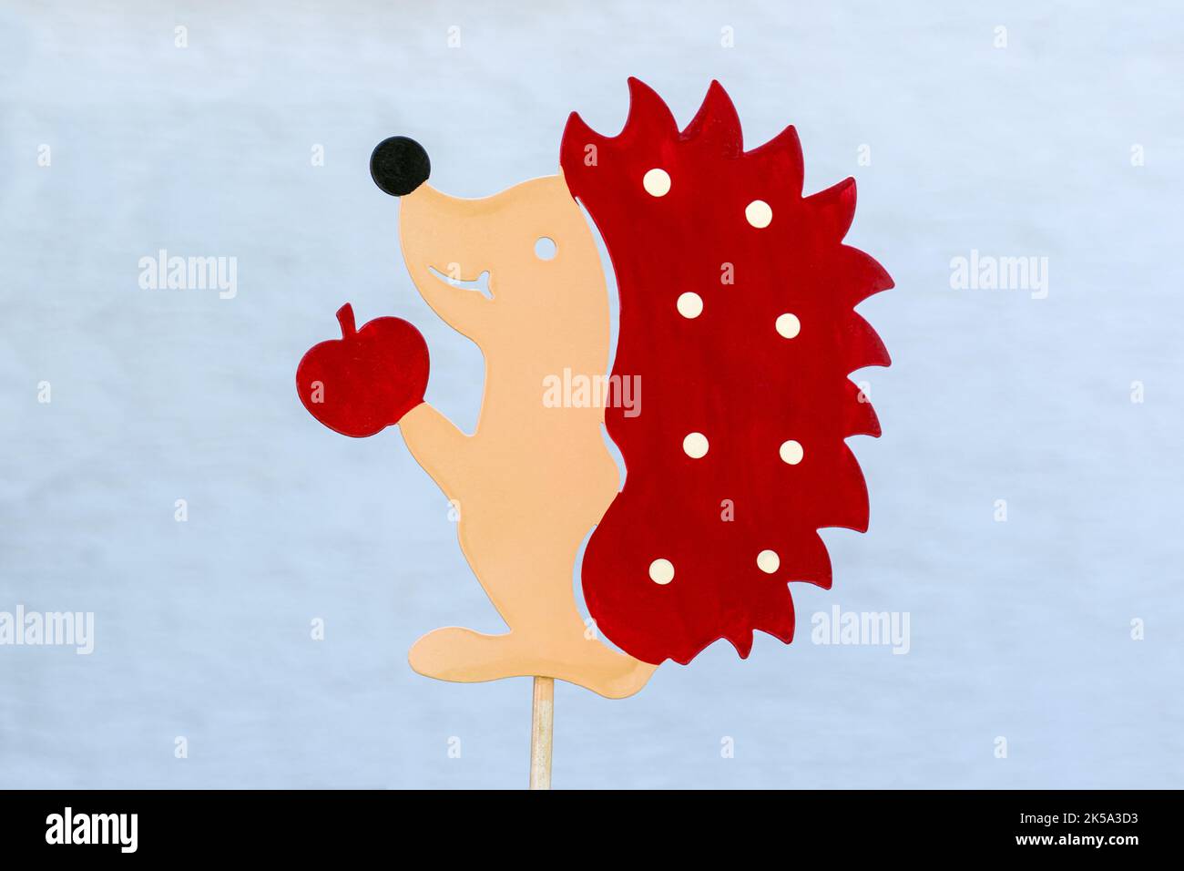 Hedgehog with apple - childlike figure made of painted metal on a rod Stock Photo