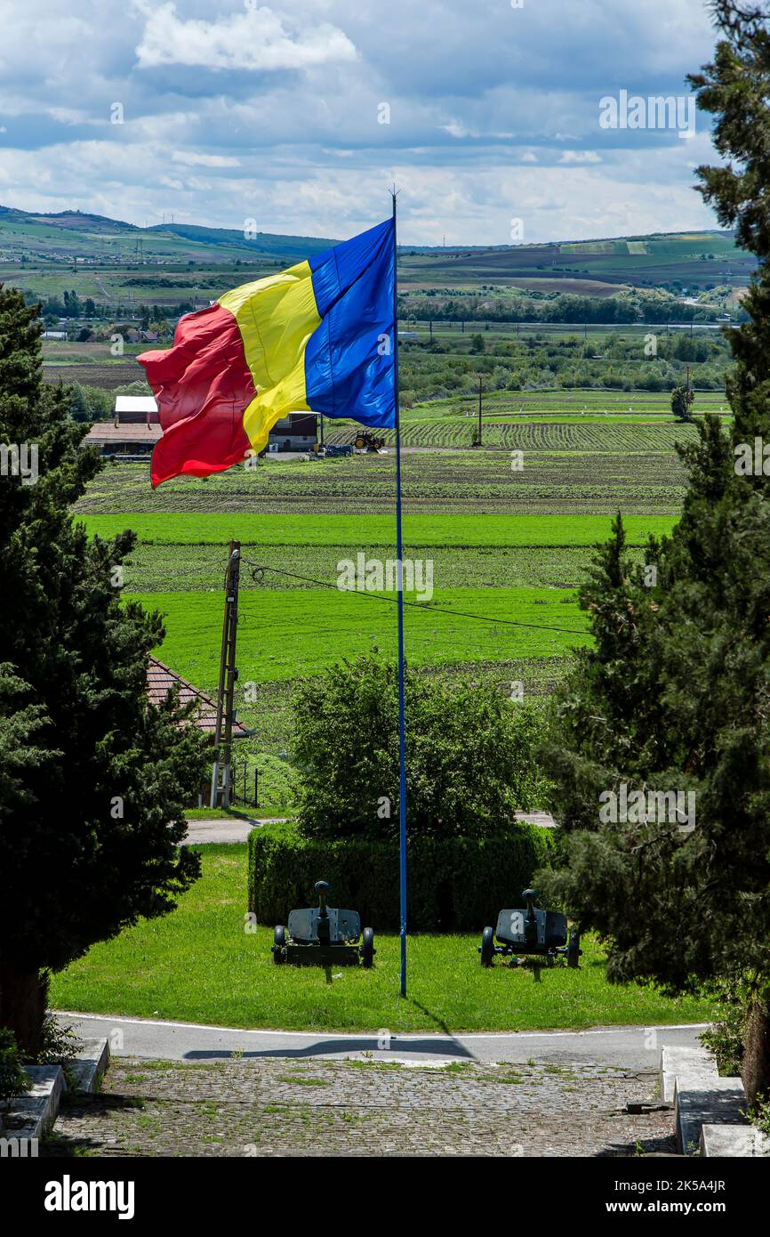 Romanian flag and Cannons placed at the monument to Romanian heroes of World War II on may 30, 2021 in Oarba de Mures, Transylvania Stock Photo
