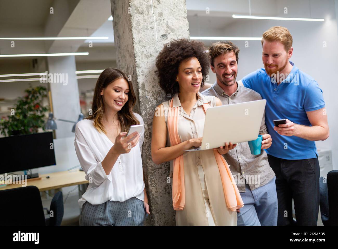 Group of software engineers working developing applications together in corporate office Stock Photo