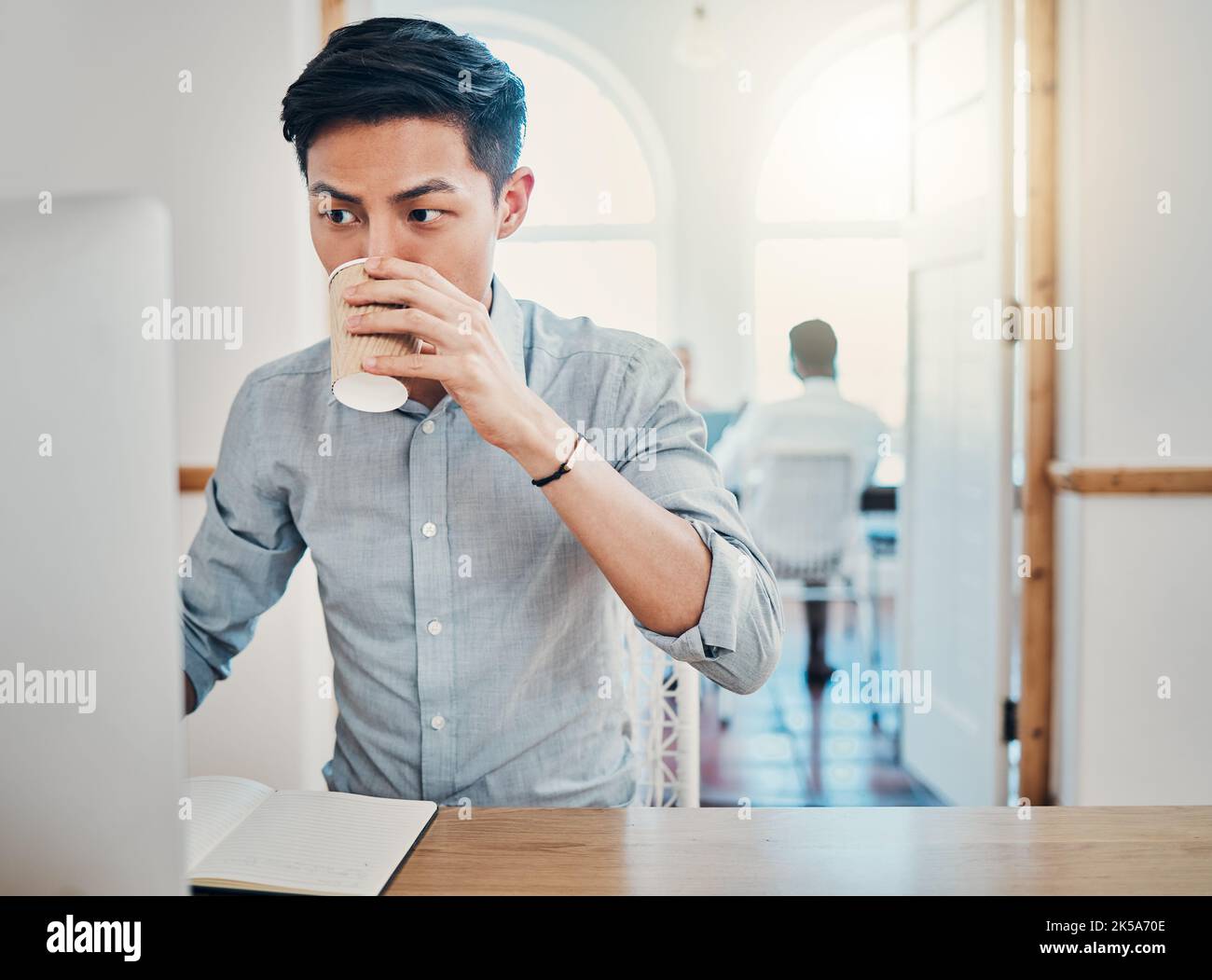 Coffee, computer and notebook with a business man thinking while working at his office desk. Idea, email and report with a male asian employee at work Stock Photo