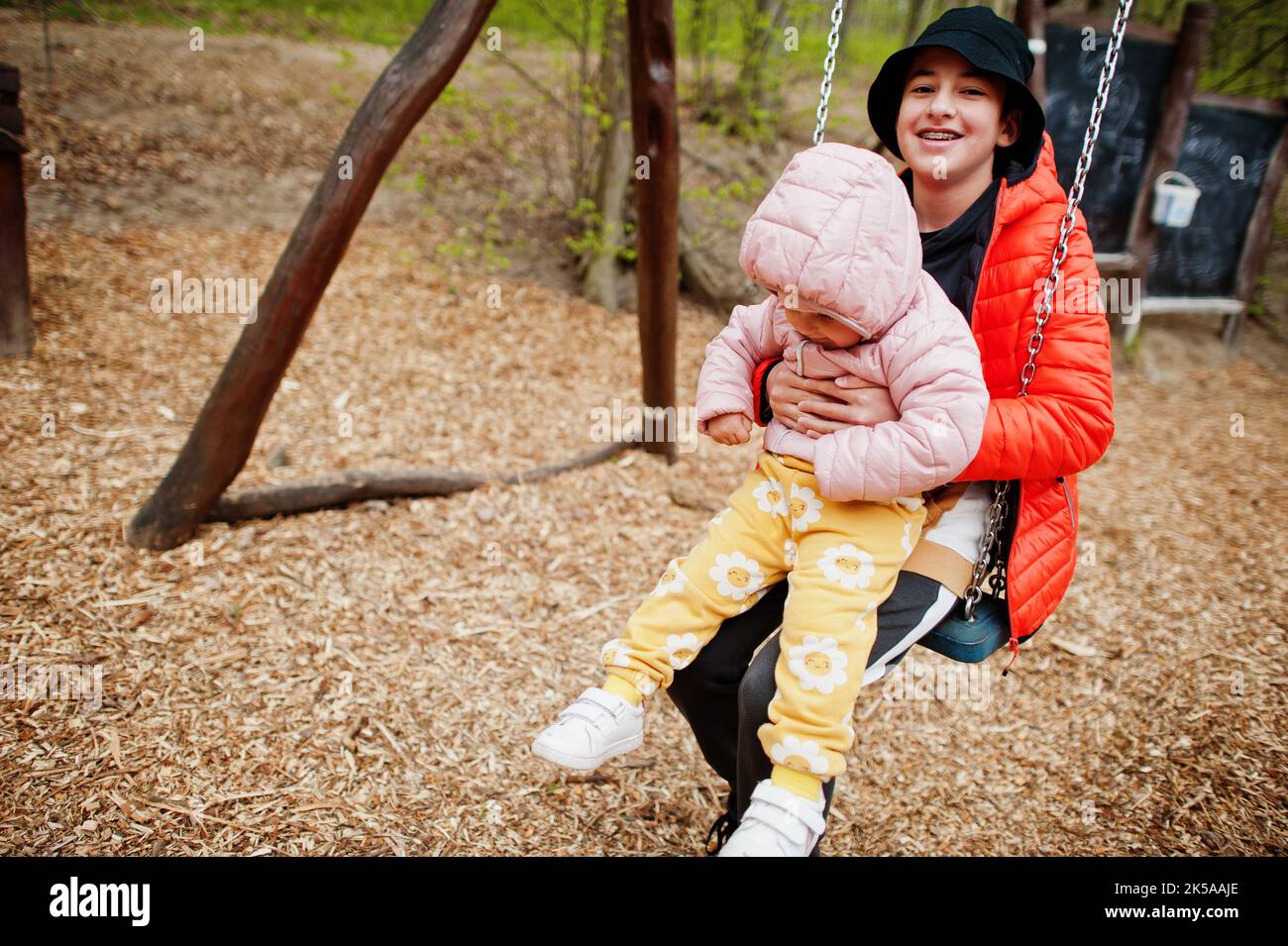 Brother with sister on a swing Stock Photo - Alamy