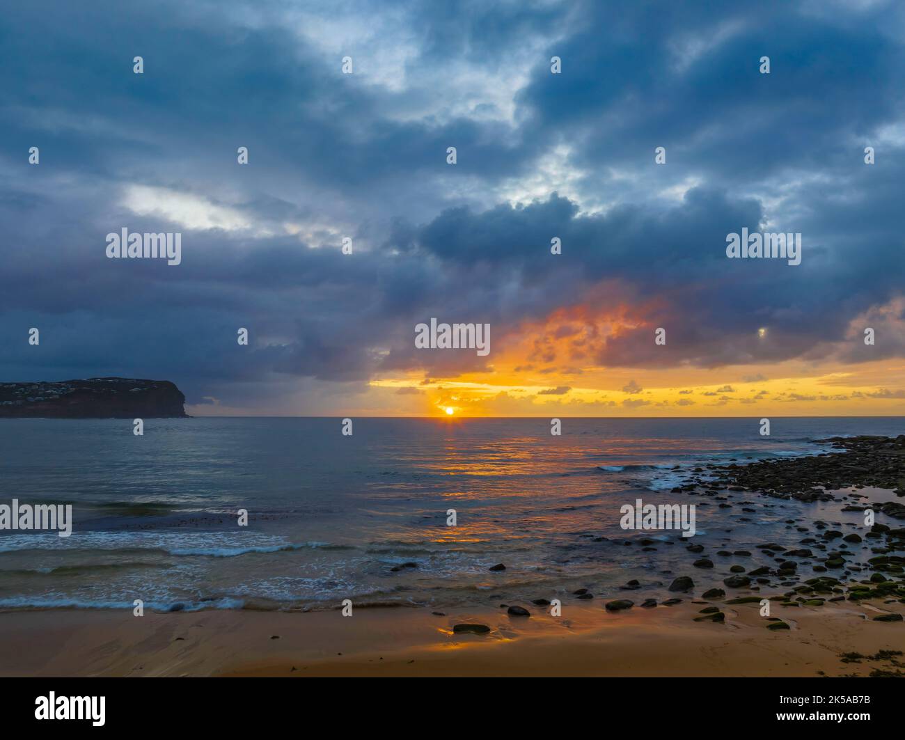 Aerial sunrise with rain clouds and small waves at  Macmasters Beach on the Central Coast, NSW, Australia. Stock Photo