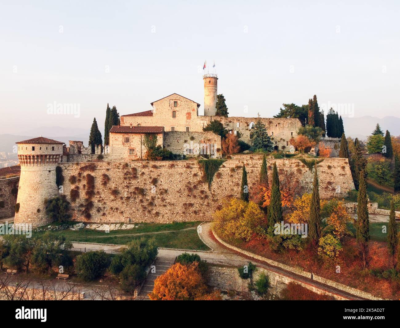 Maxi panoramic drone view on ancient medieval castle in Brescia on top of Cidneon mountain enframed by autumn park. Brescia, Lombardy, Northern Italy Stock Photo