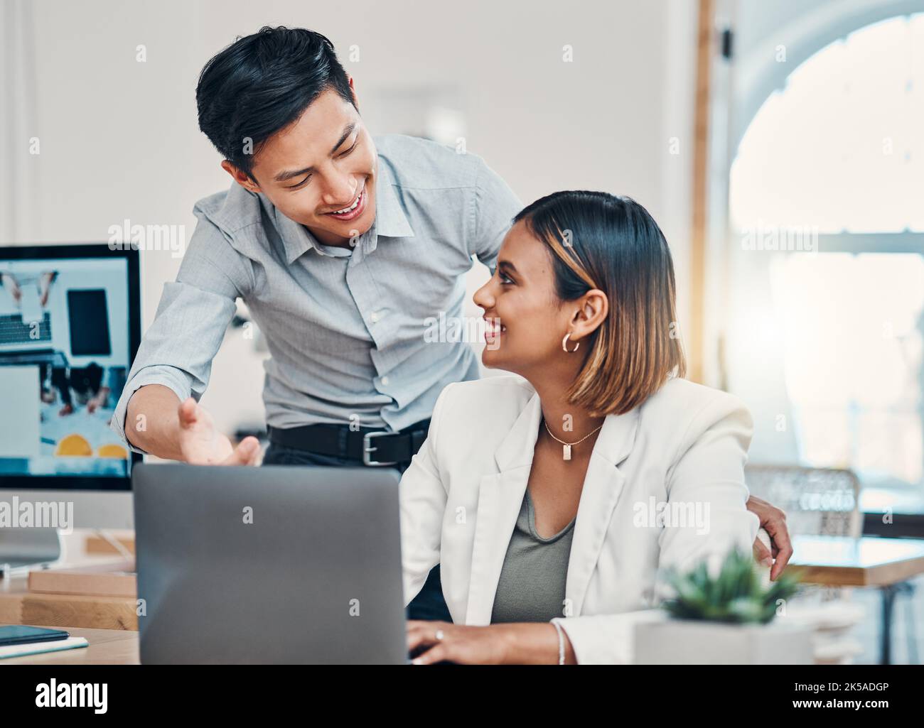 Startup company training, working people at desk and asian manager coaching employee in Singapore office. Indian woman learning finance advice Stock Photo