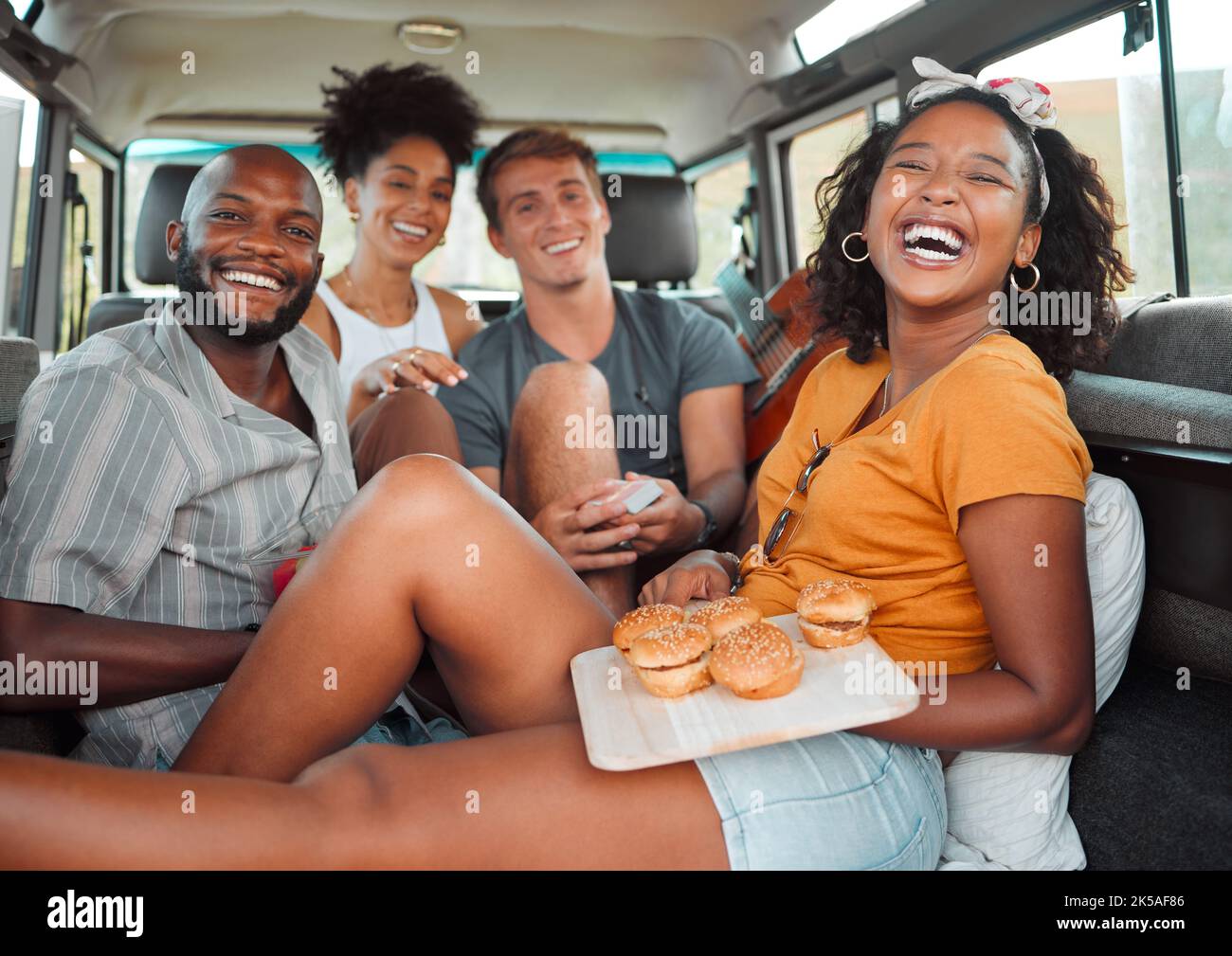 Food, travel and friends eating on a road trip, happy, relax and laughing while bonding in a car together. Fast food, diversity and face portrait of Stock Photo