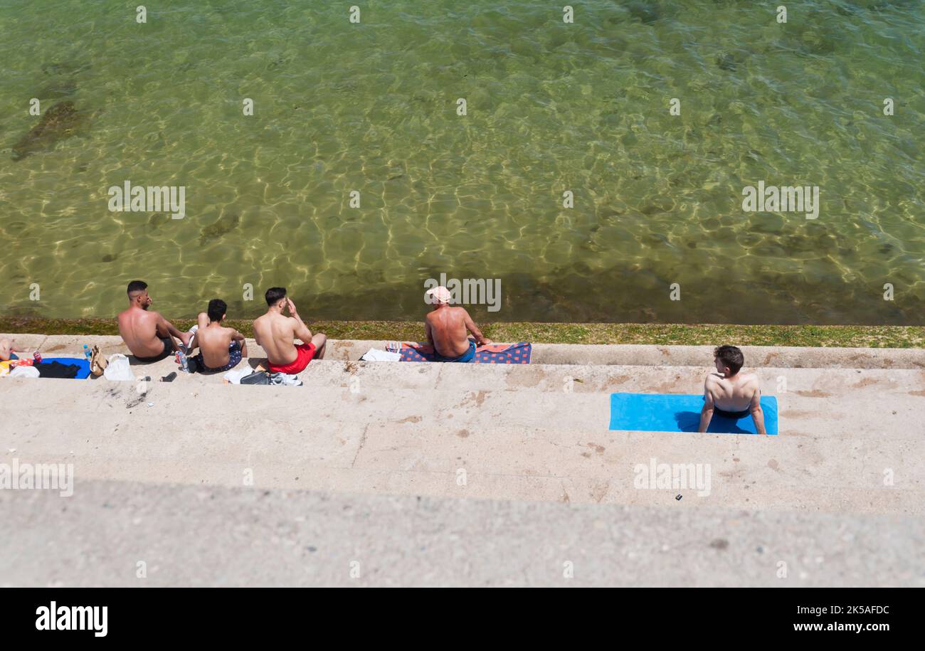 People Sunbathing in spring, Barceloneta beach, Barcelona, Spain Stock Photo