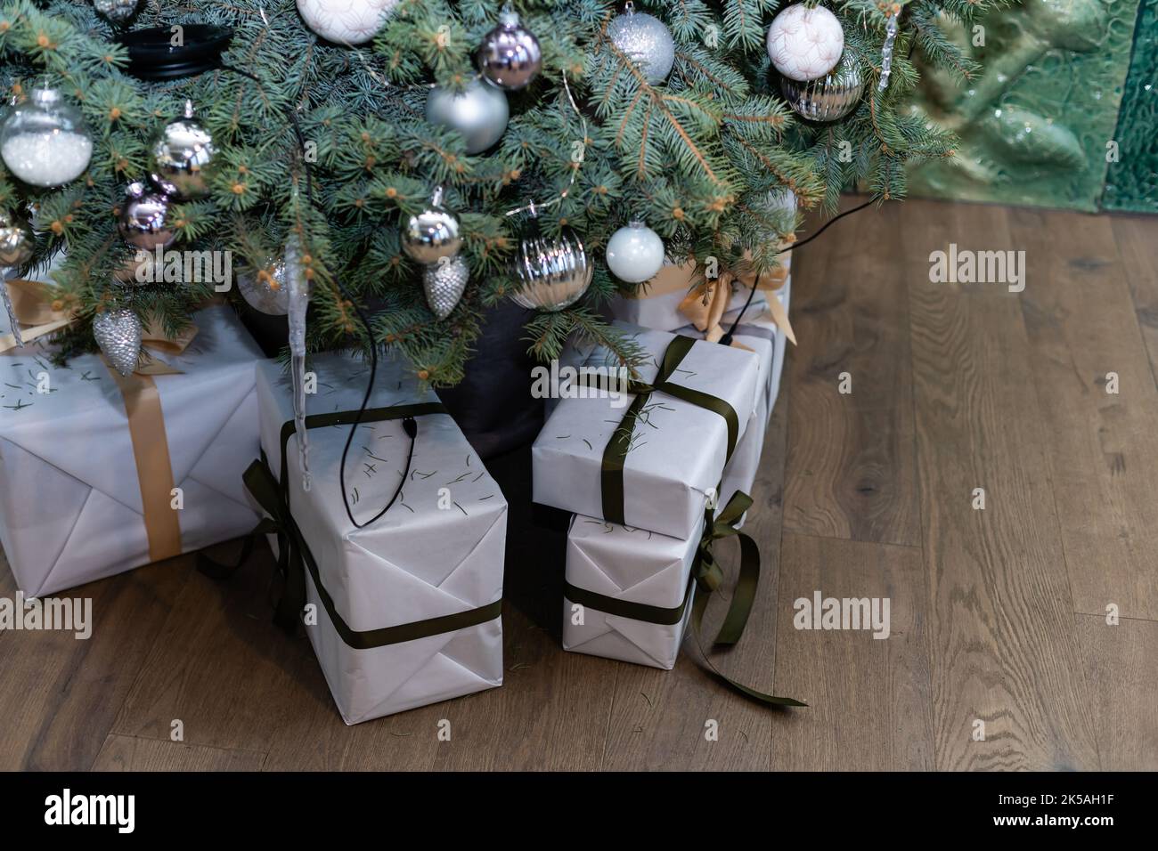 Beautiful Christmas gift boxes on floor near fir tree in room Stock ...