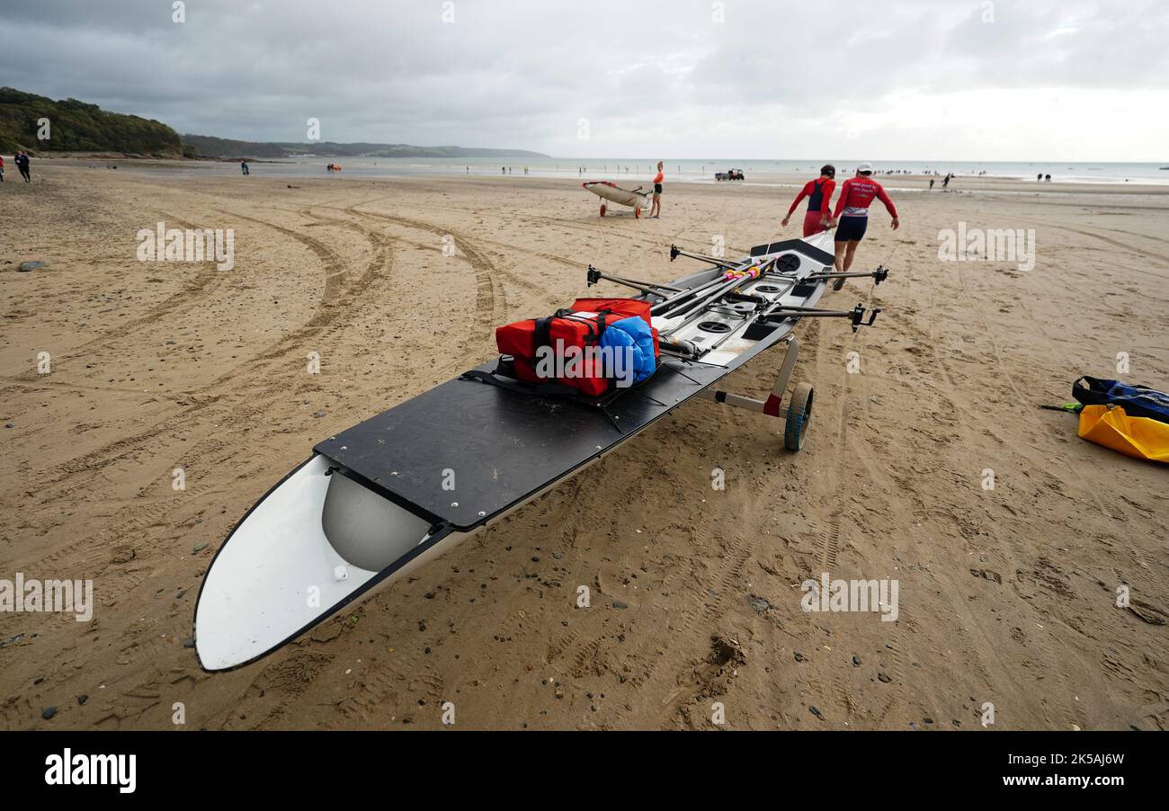 Rowers carry their boat to the sea during the World Rowing