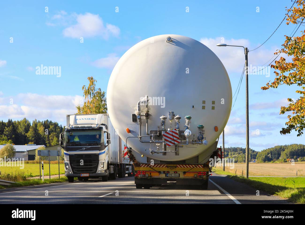 Rear view of oversize load transport of LNG storage tank on highway, truck from opposite direction takes caution. Salo, Finland. Sept 22, 2022. Stock Photo