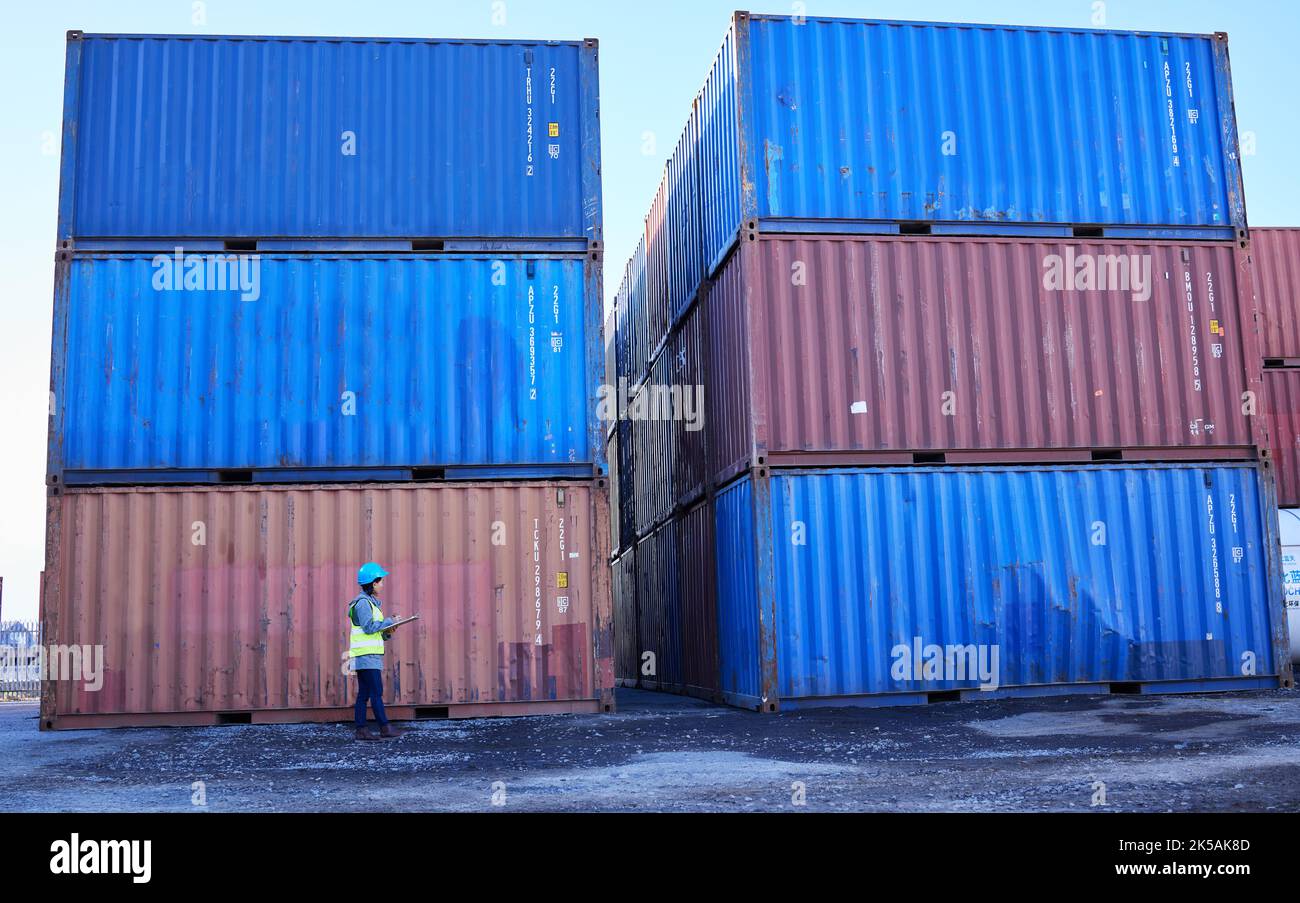 Logistics, supply chain and woman in container port checking inventory list for global freight company. Industrial shipping yard, female inspector Stock Photo