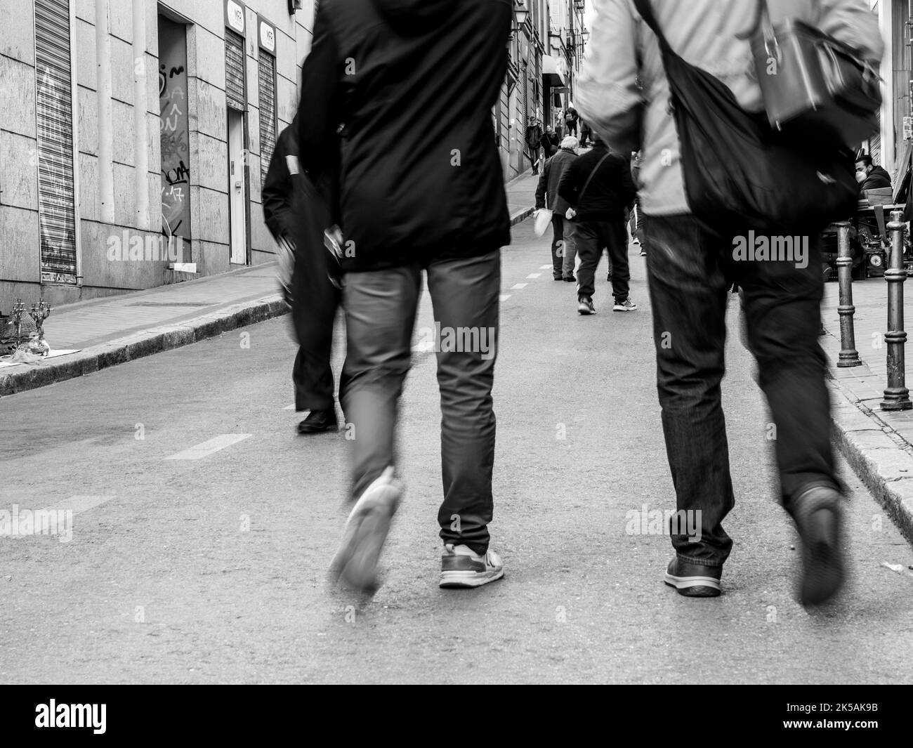 Black and white photography of people walking outdoors on the street. Stock Photo