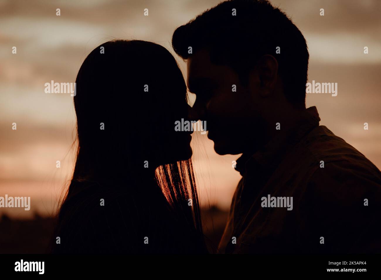 The silhouette of a couple kissing romantically during the sunset Stock ...