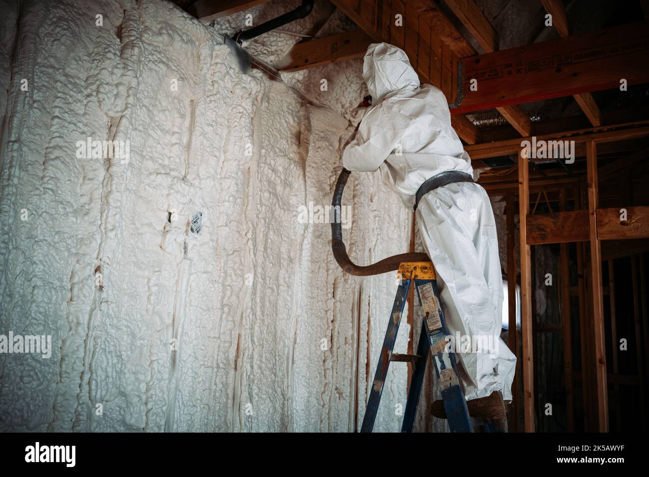 A worker doing spray foam insulation on the walls Stock Photo - Alamy