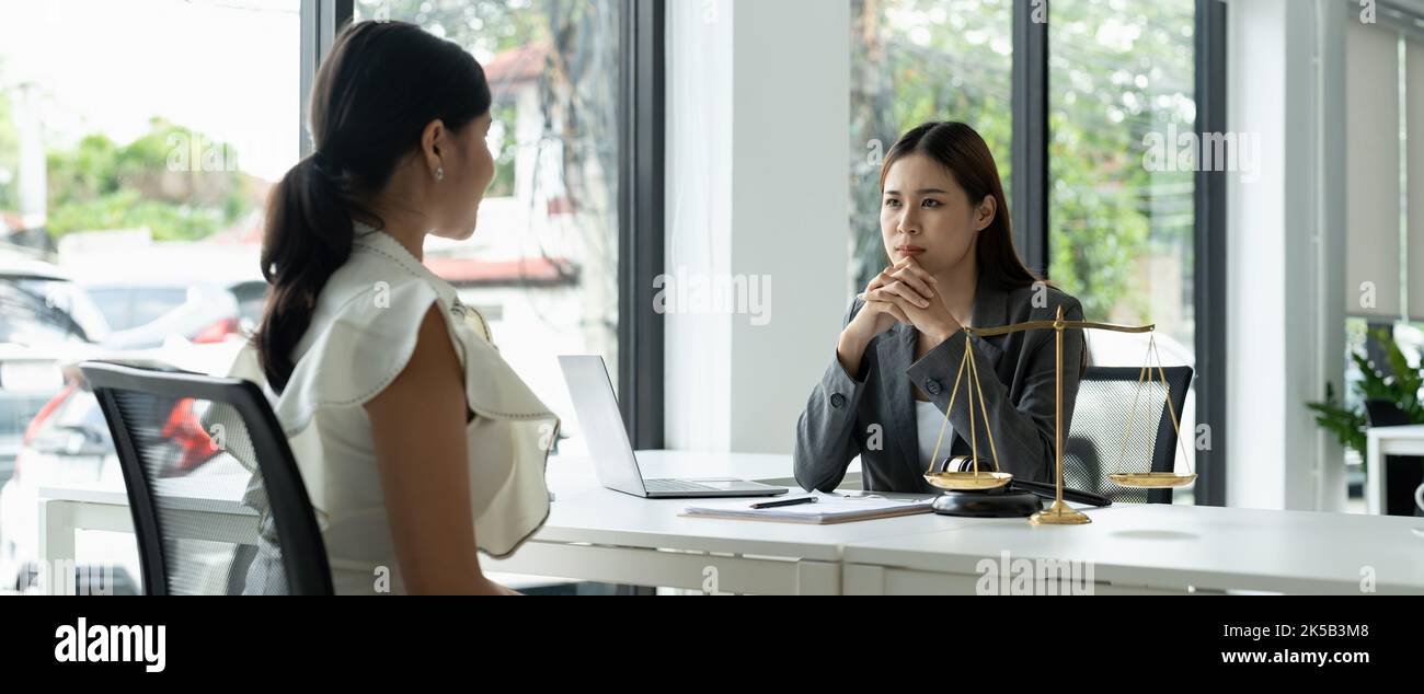 Asian female lawyer discussing negotiation legal case with client meeting with document contact in courtroom, law and justice concept Stock Photo