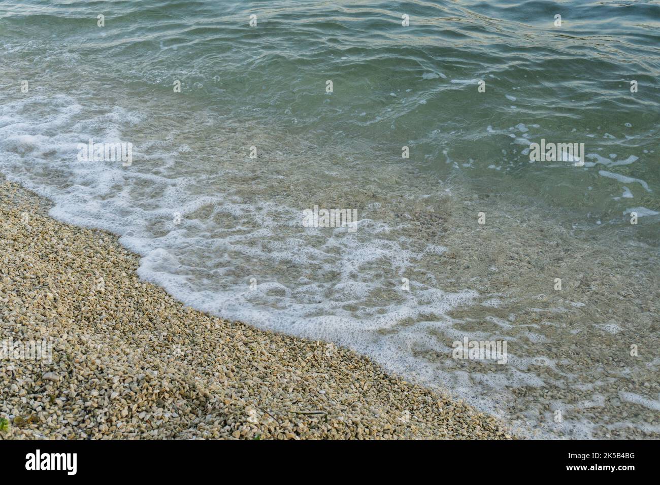 A top view of the foam of sea waves hitting the rocky shore Stock Photo ...