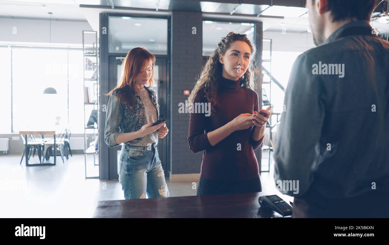 Busy work day at cozy coffeehouse with customers standing at counter
