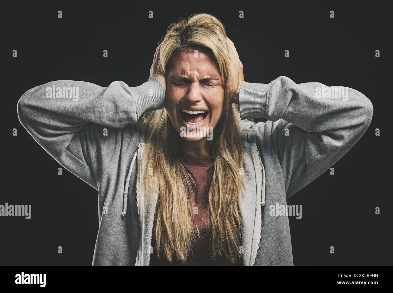 Anxiety, bipolar woman crying, frustrated or crazy on a dark studio for psychology and mental health mock up. Trauma, schizophrenia or depressed girl Stock Photo
