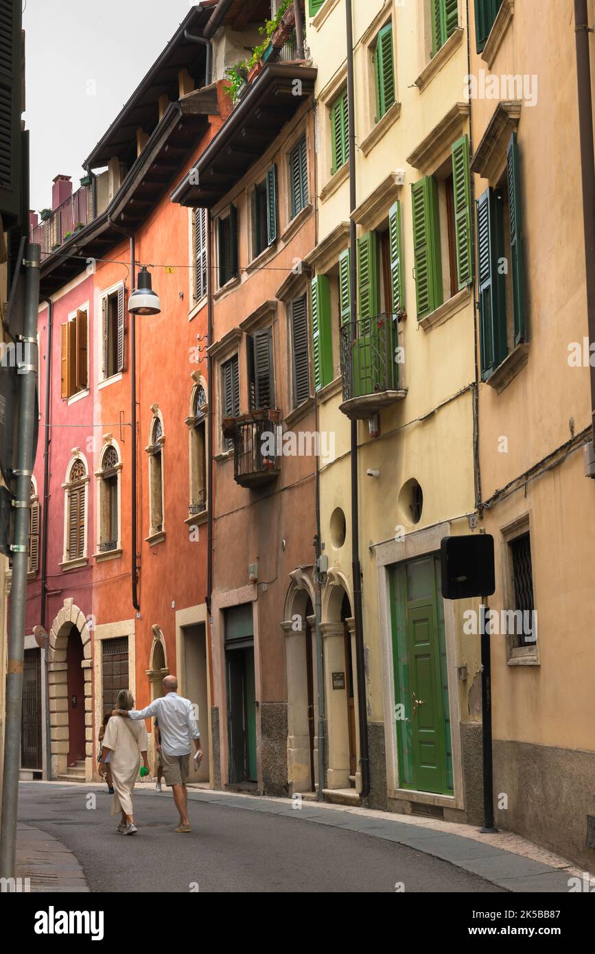 Mature couple travel, rear view of a middle aged couple walking in a scenic street in the historic center of the city of Verona, Italy Stock Photo
