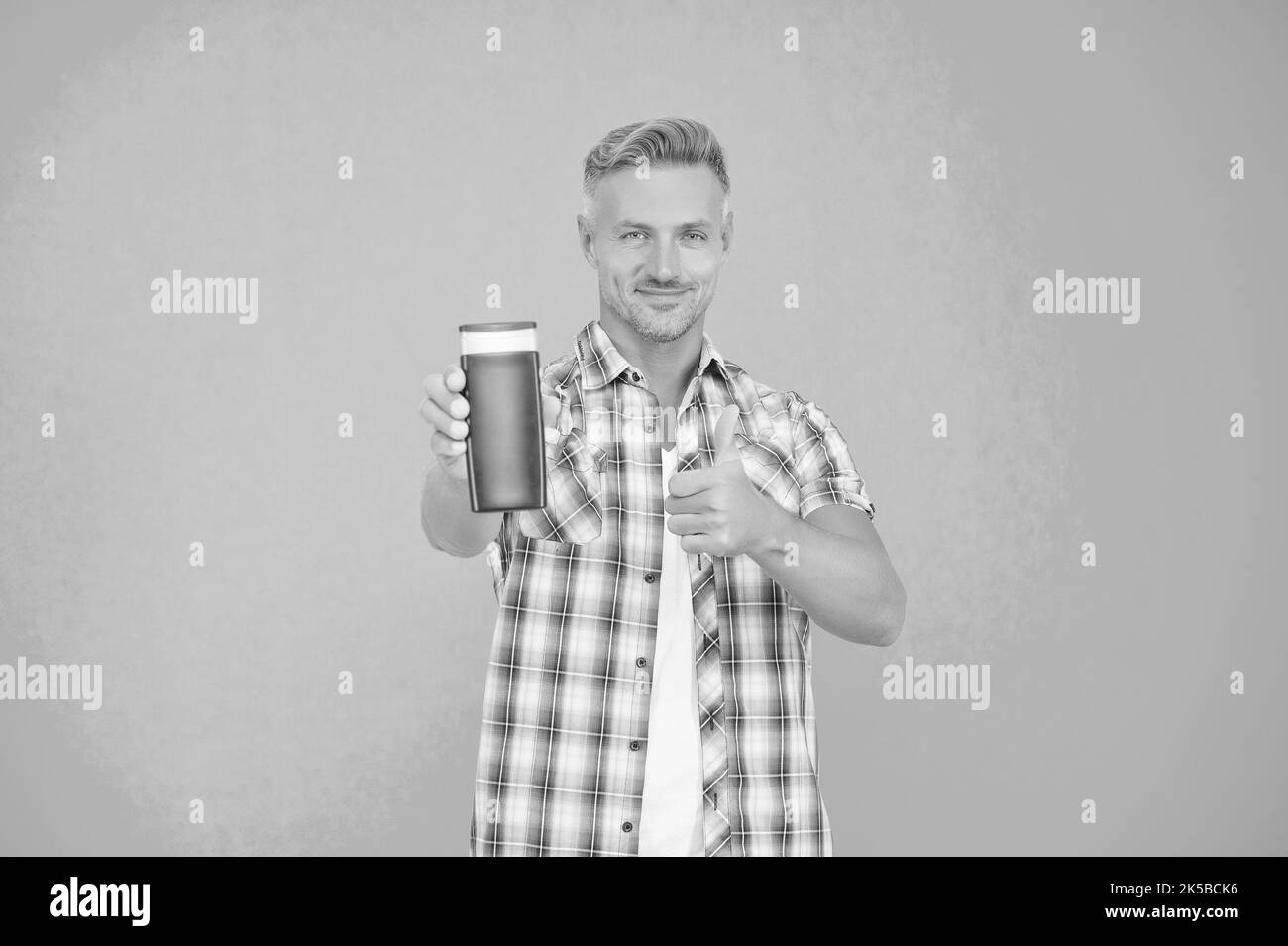 Happy guy give thumbs up hand gesture to mens gel bottle blue