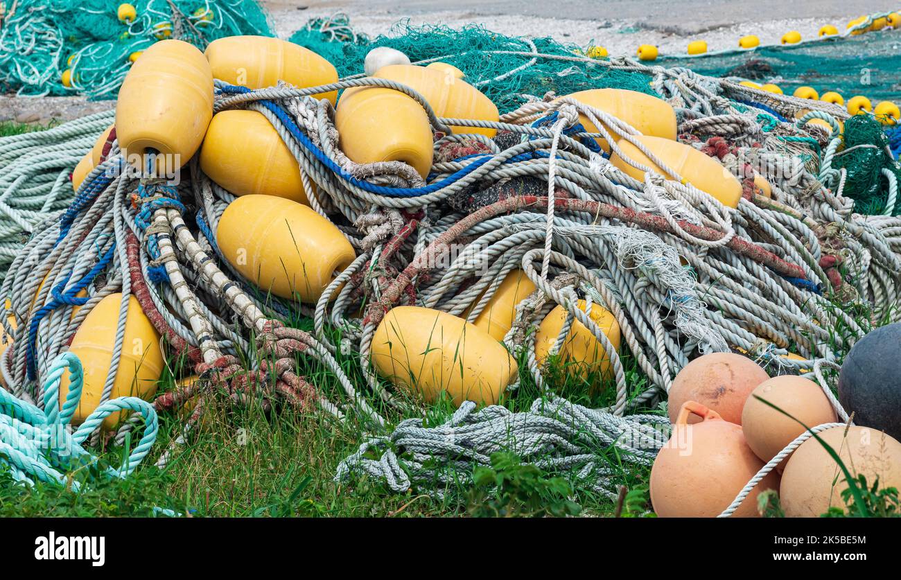 industrial fishing nets with bright floats is folded ashore Stock Photo