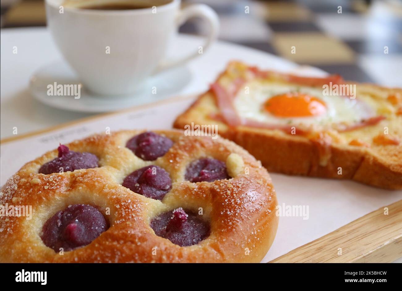Closeup of Sweet Potato Puree Bun with Blurry French Toast and Coffee in the Backdrop Stock Photo