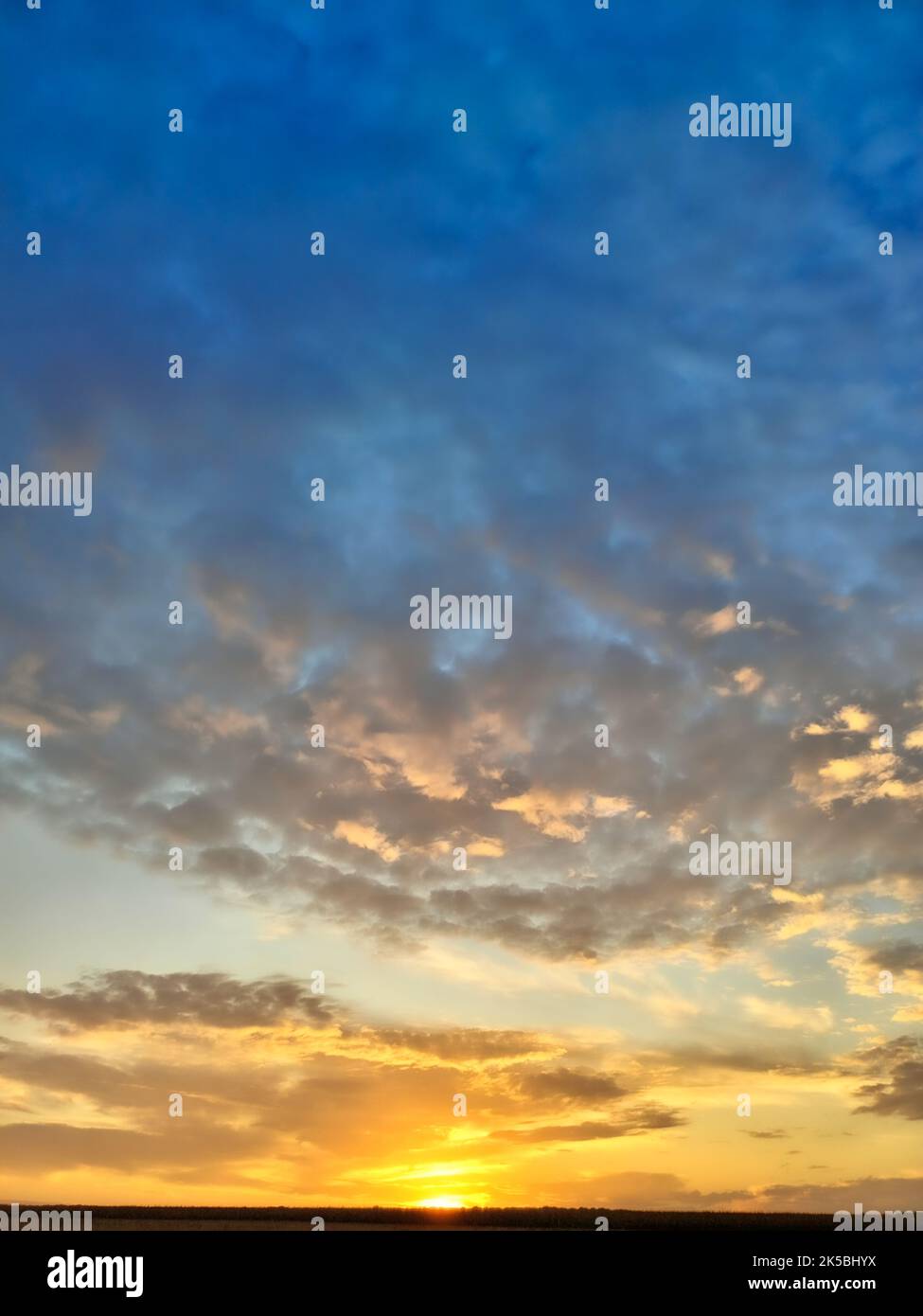 Abstraction of colorful orange and blue clouds in the sky during sunset. Stock Photo