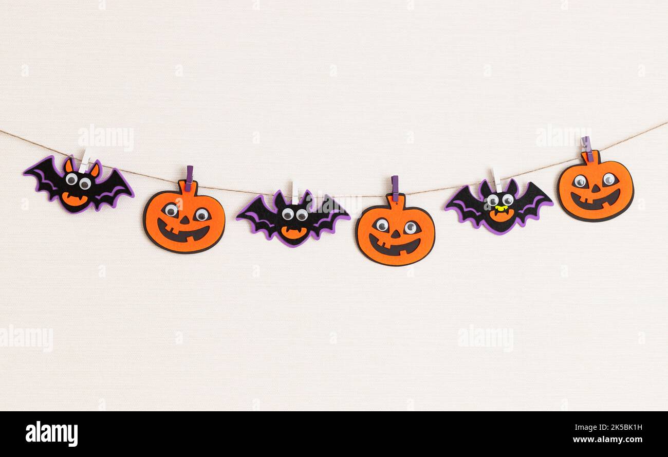 Halloween decoration on wall, pumpkins and bats garland with scary faces Stock Photo