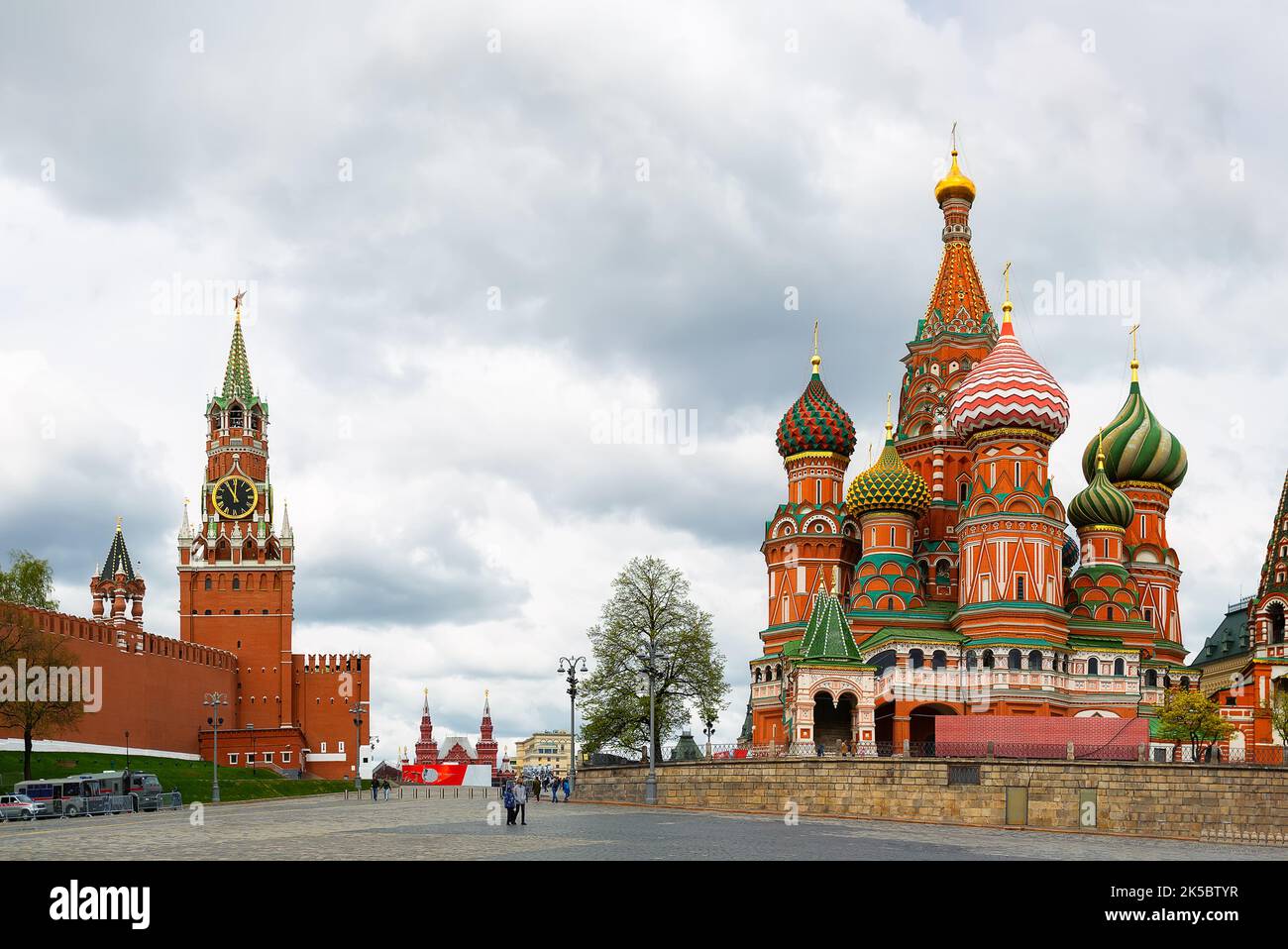 St. Basil's Cathedral on Red square and Moscow Kremlin with Spasskaya tower on a dramatic cloudy sky background in summer day, Moscow, Russia. Stock Photo