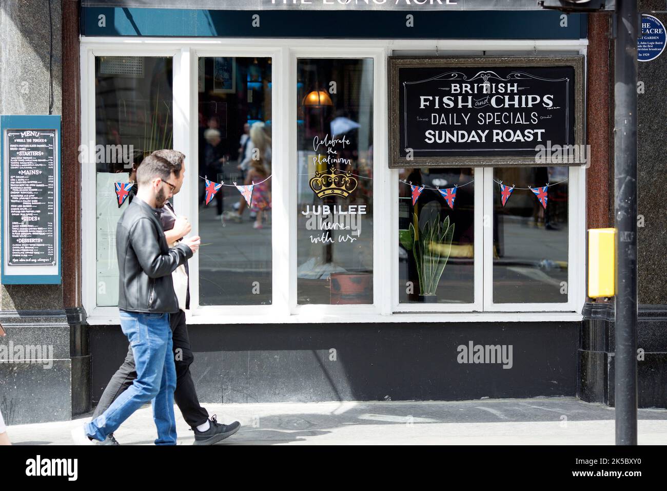 Platinum Jubilee decorations are seen on the window of a pub in central