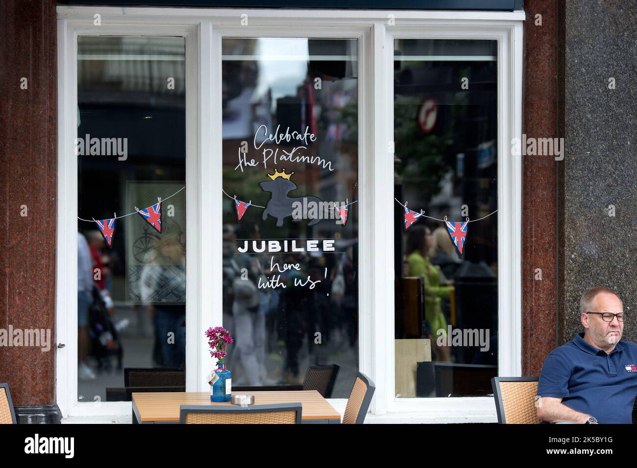 Platinum Jubilee decorations are seen on the window of a pub in central