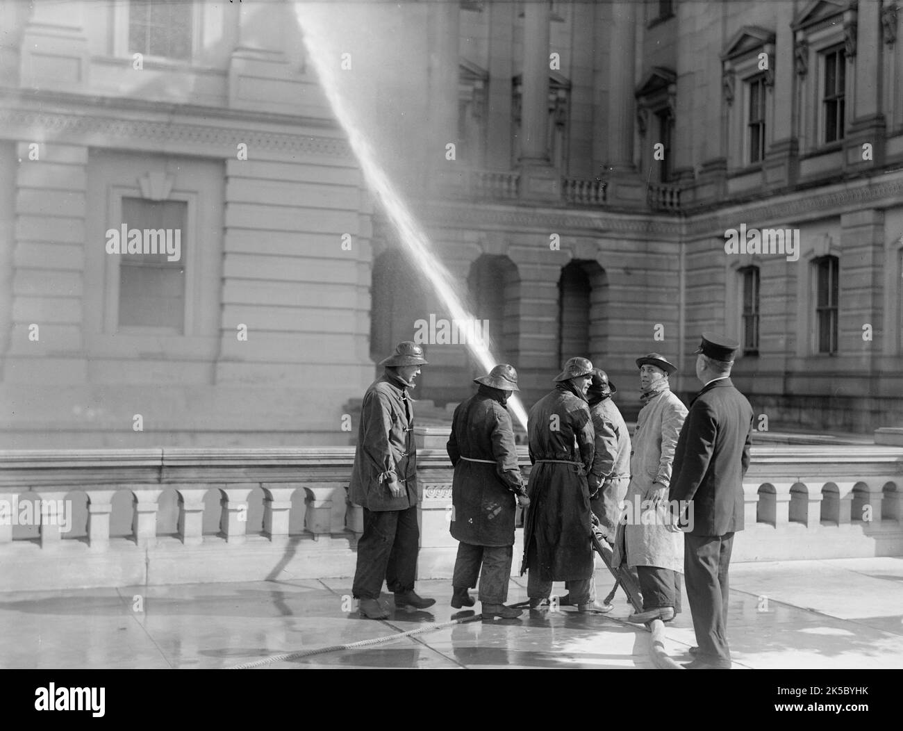 U.S. Capitol - Cleaning Exterior, 1913. Firefighters in sou'westers with pressure hose, Washington DC. Stock Photo