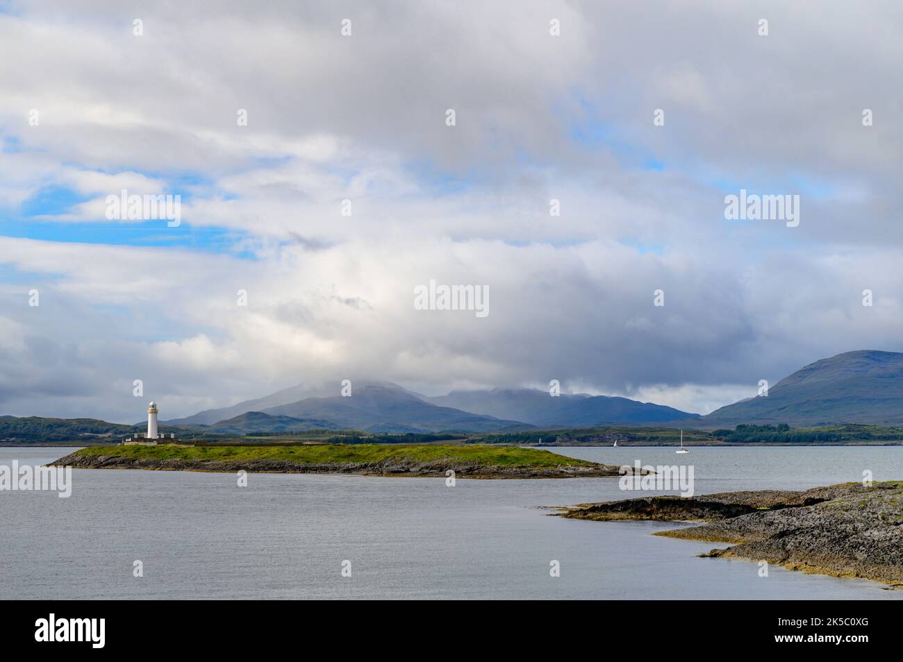 Eilean Musdile Lighthouse and the hills of Mull from Rubha Fiart on the Isle of Lismore,. Scotland Stock Photo