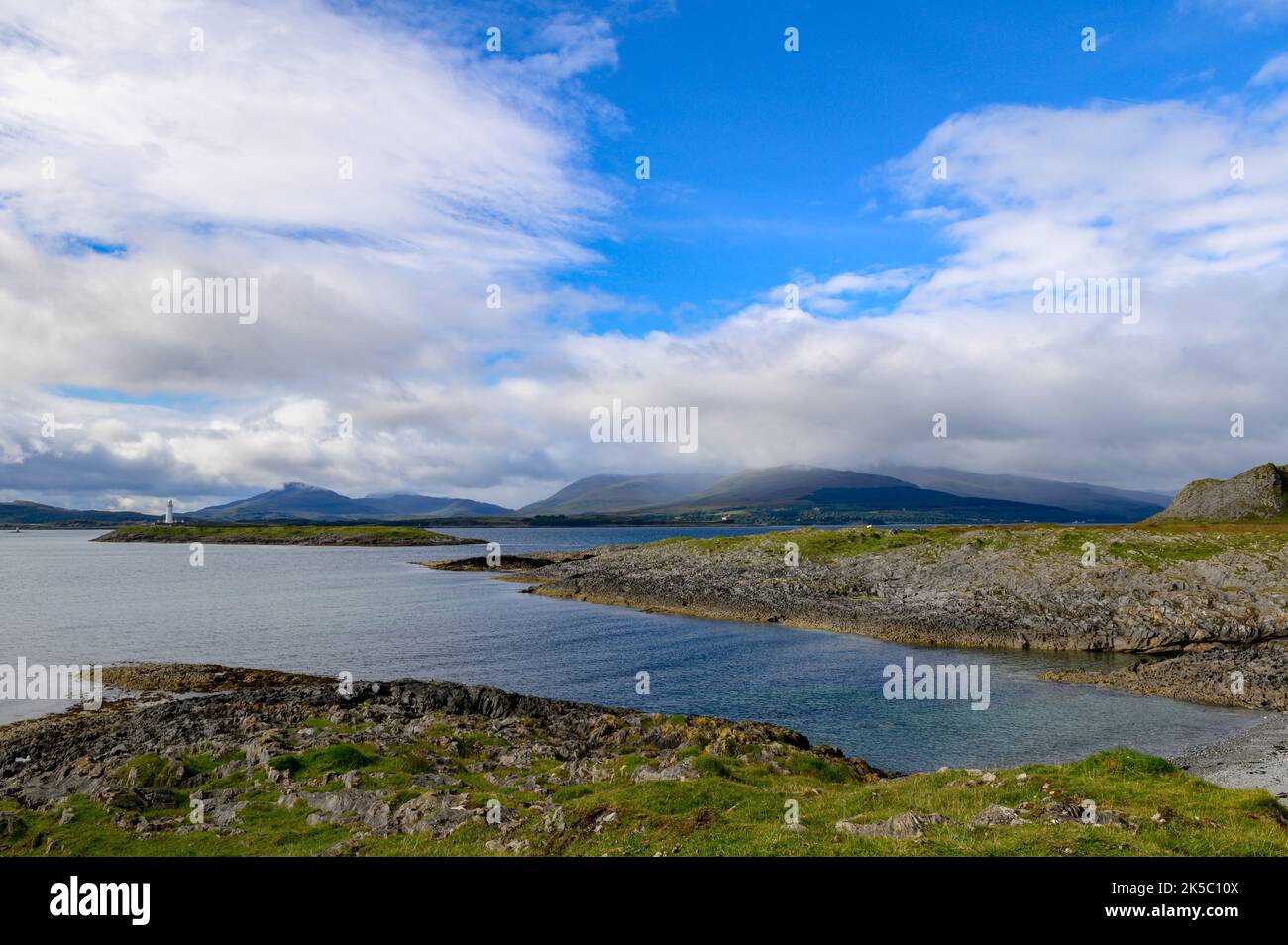 Eilean Musdile Lighthouse and the hills of Mull from Rubha Fiart on the Isle of Lismore,. Scotland Stock Photo