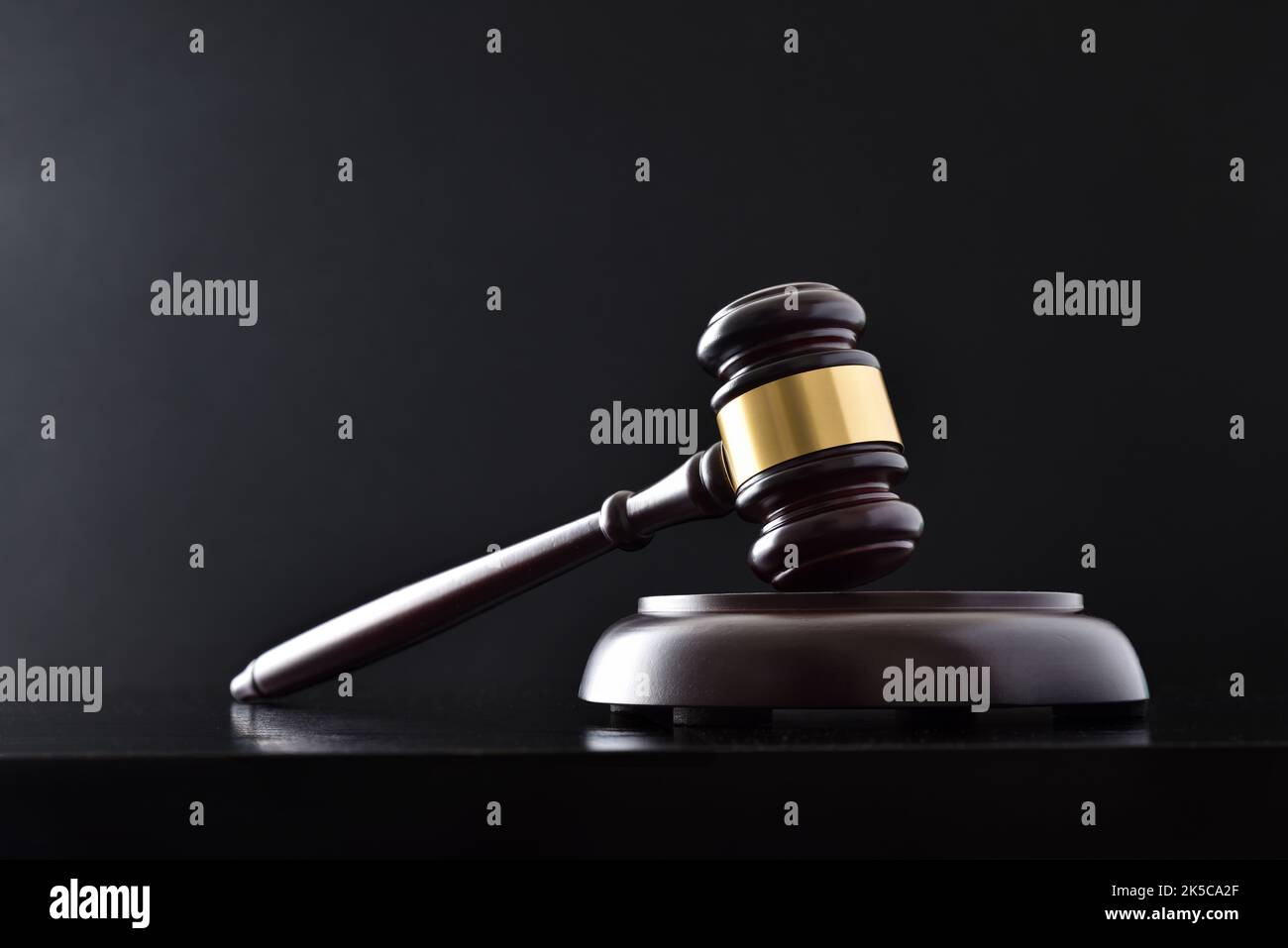 Background of judge's gavel on white table and black isolated background. Front view Stock Photo
