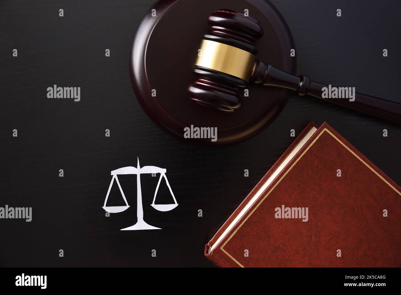 Objects symbols of justice such as scales mace and law book on black table. Top view Stock Photo