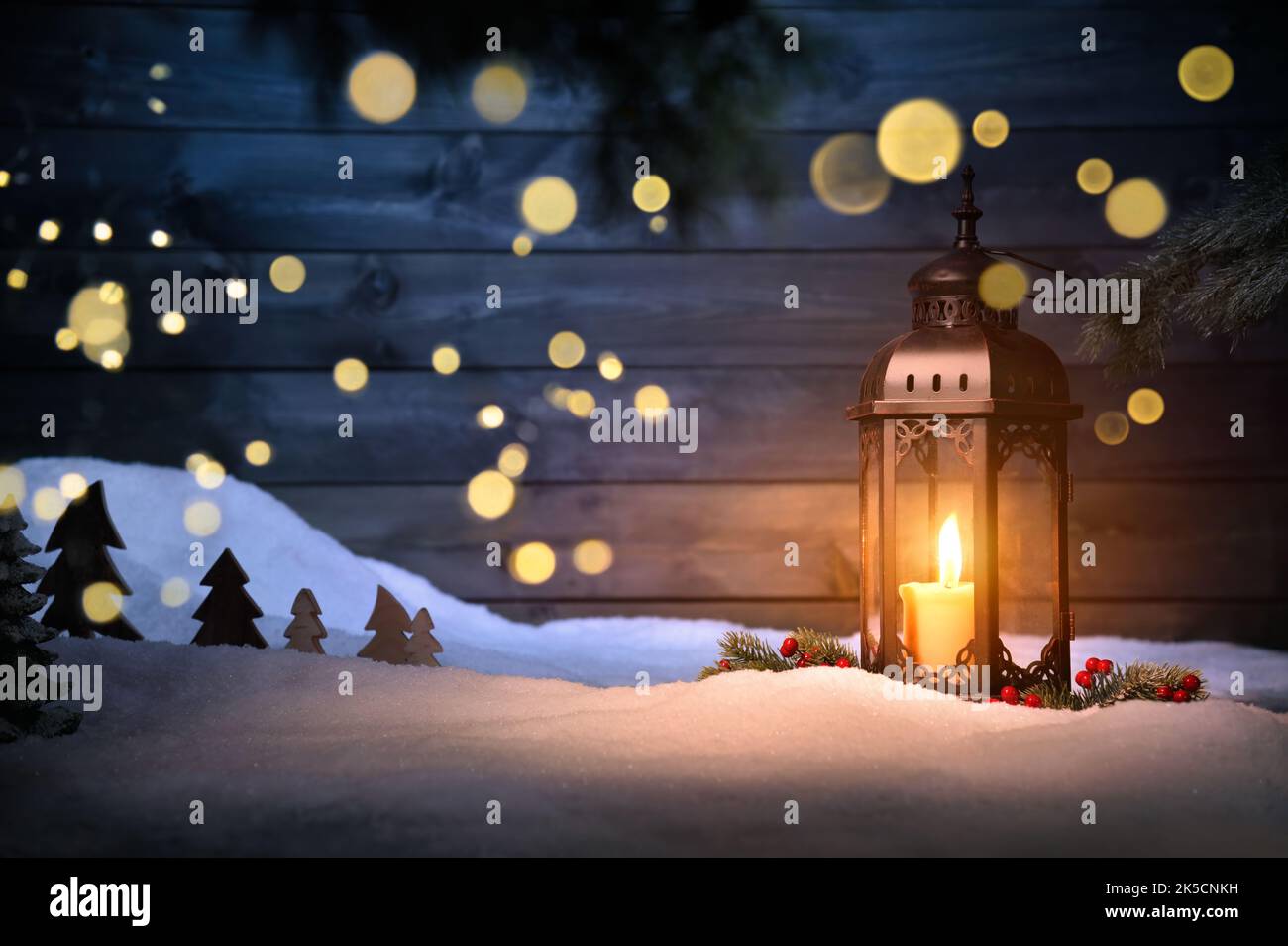 Christmas scene with a lantern, ornaments and blurred lights hanging in ...