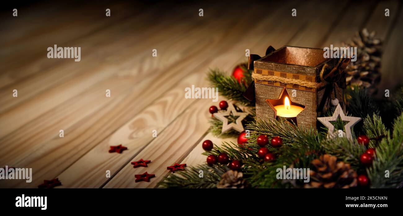 Christmas or advent background with a candle burning in a lantern on an elegant wooden surface, low key mood Stock Photo