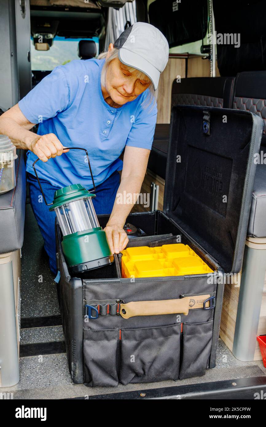Woman storing camping gear in Radius Outfitters Gear Box 500 Stock Photo